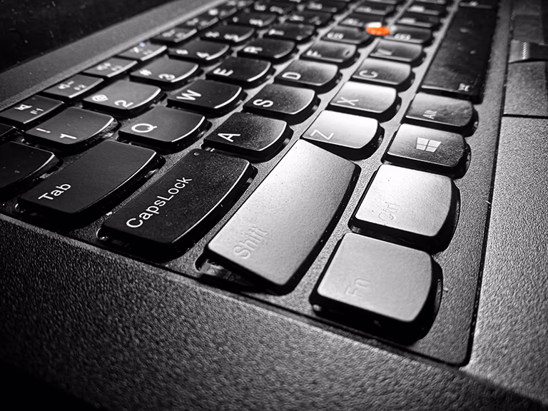 A close-up of a ThinkPad T480's left shift key, cap angled upwards in place due to improper removal from the top.
